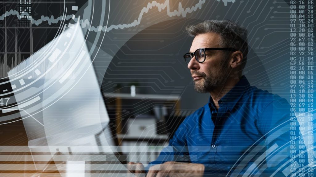 Man analyzing data on a computer screen with digital data overlays