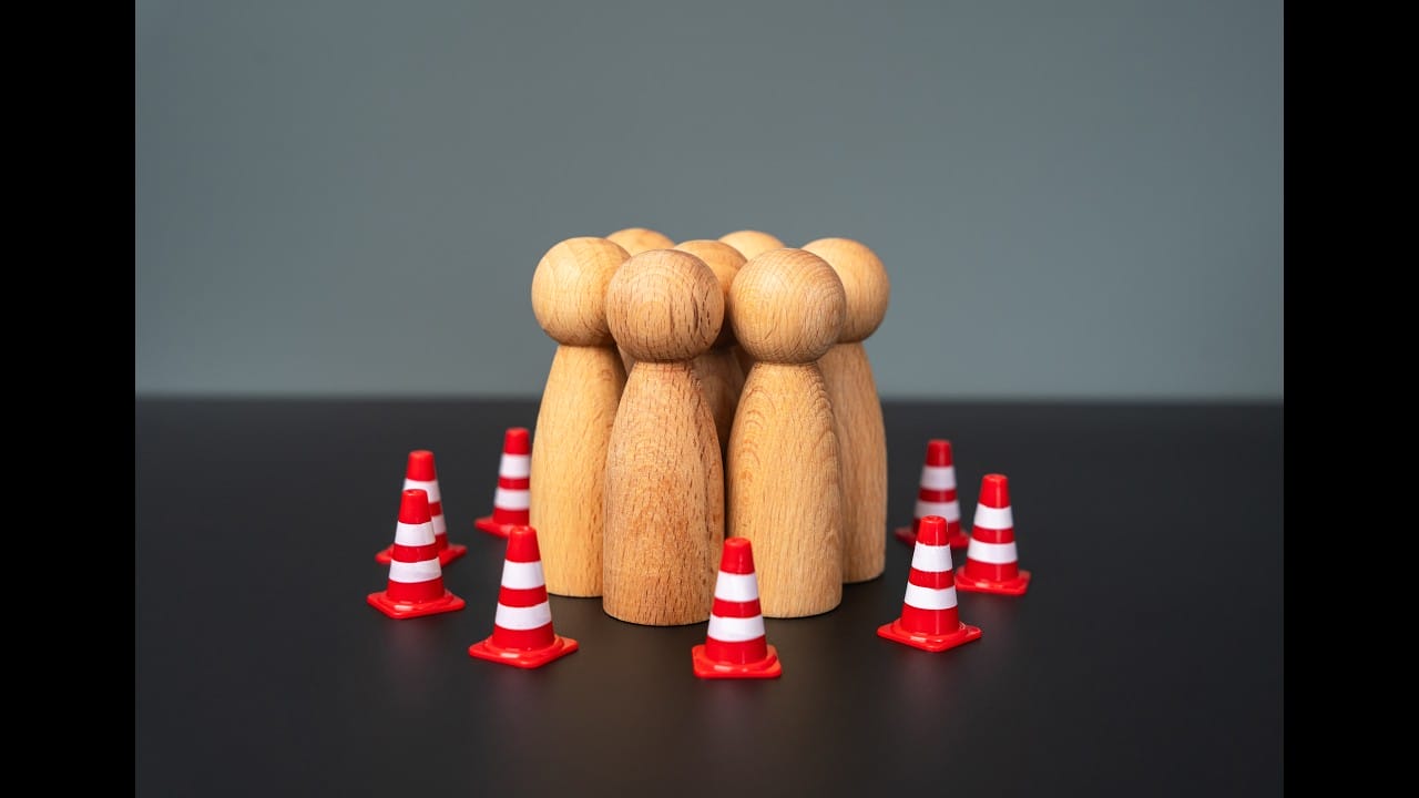 figures de personnages simples en bois entourés de cônes de construction